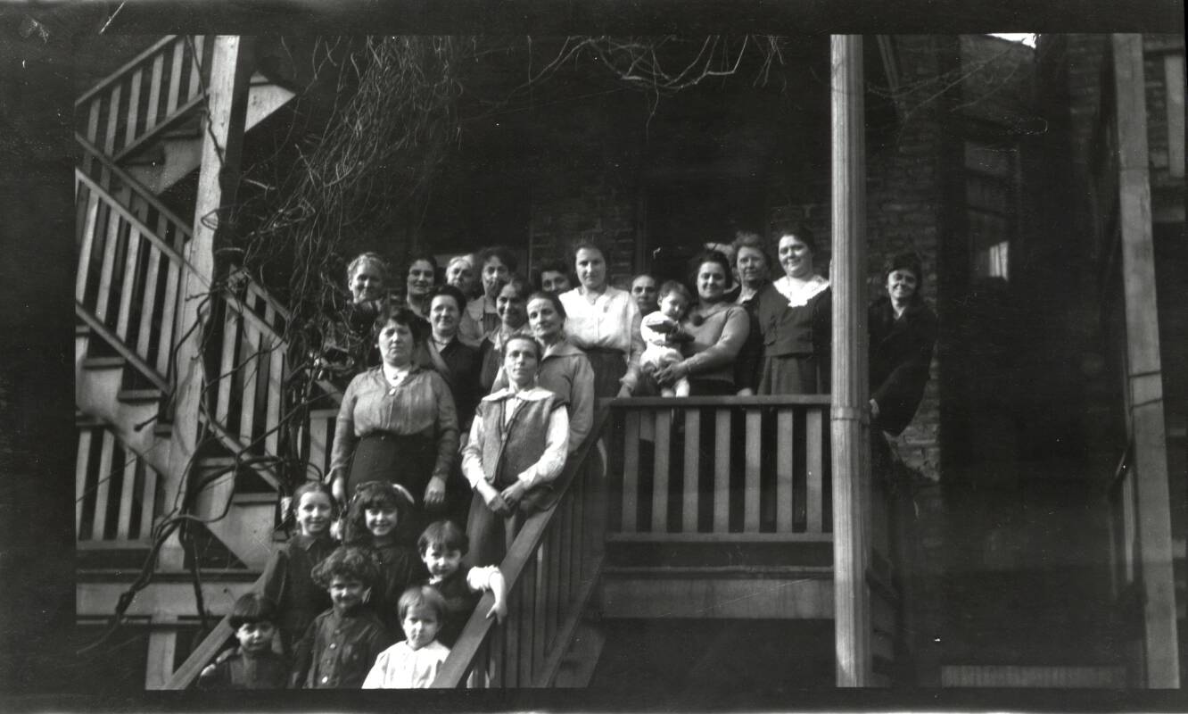 Women and children on the back stairs of a building, Marcy-Newberry Association records.