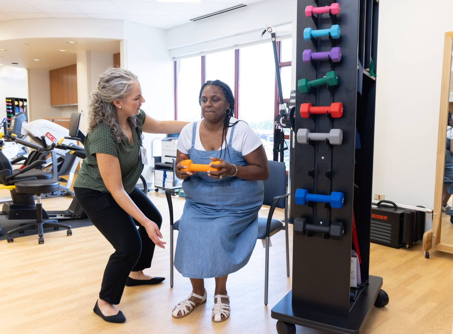 Physical therapist working with a patient holding a dumbbell