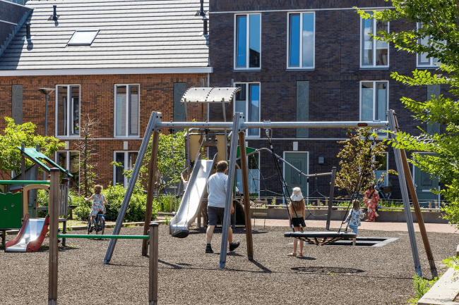 Nieuwbouwproject Hefkwartier in Rotterdam: moderne eengezinswoningen en appartementen met speelplek voor kinderen op de locatie van de voormalige Oranjeboom brouwerij.