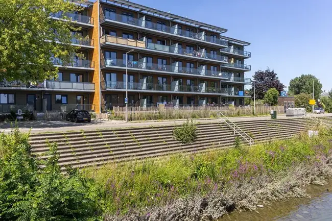 Foto toont woningen aan de Persoonsdam aan een trapkade bij water.