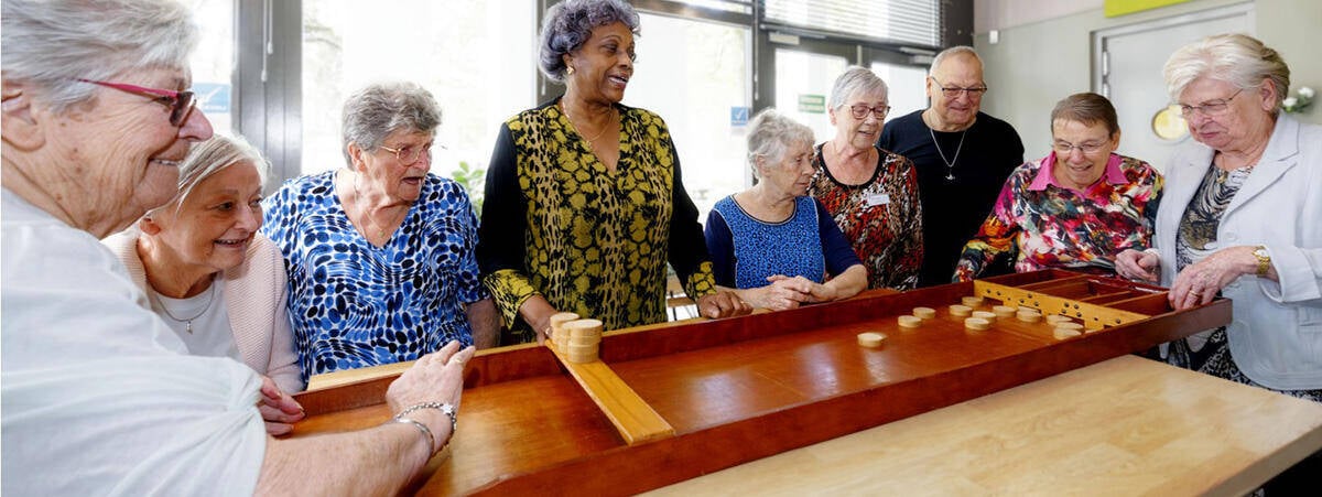 Groep ouderen aan het sjoelen