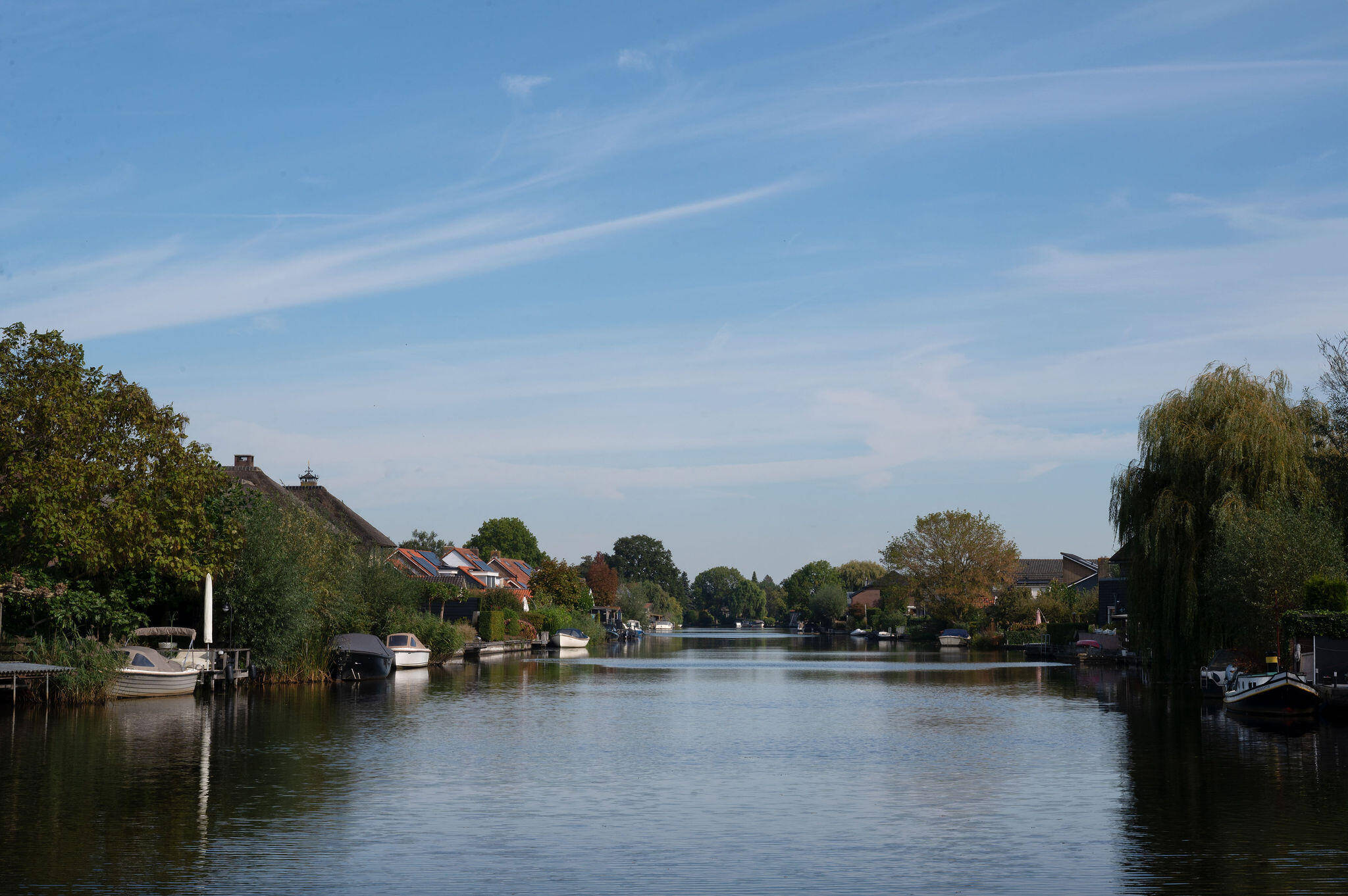 Foto van de rivier bij Giessen-Oudekerk met aan de oevers aangelegde bootjes